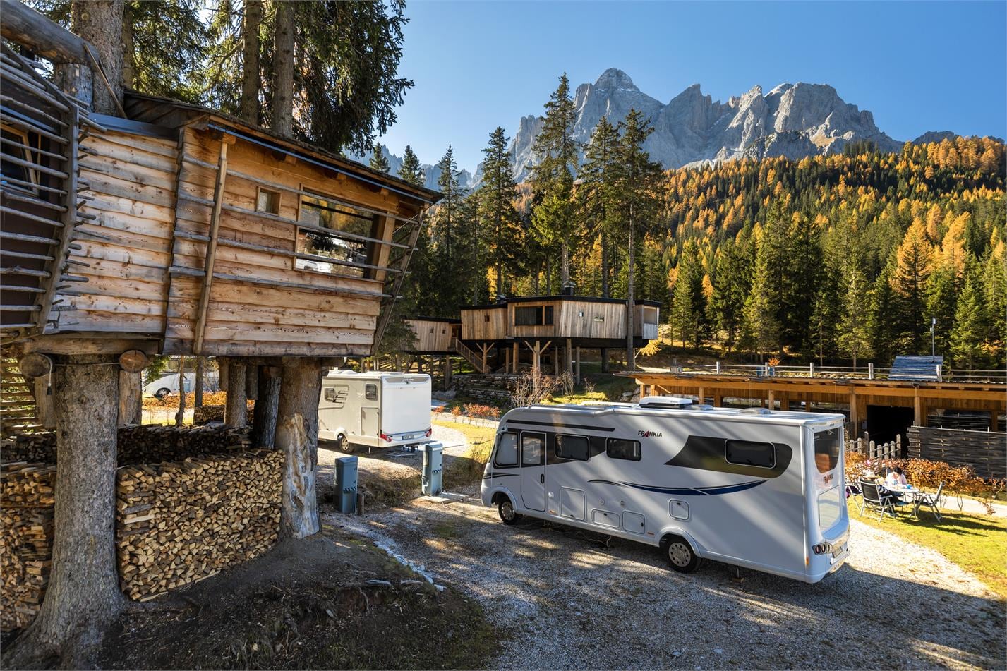 camper en boomhut met bergen en bos op de achtergrond